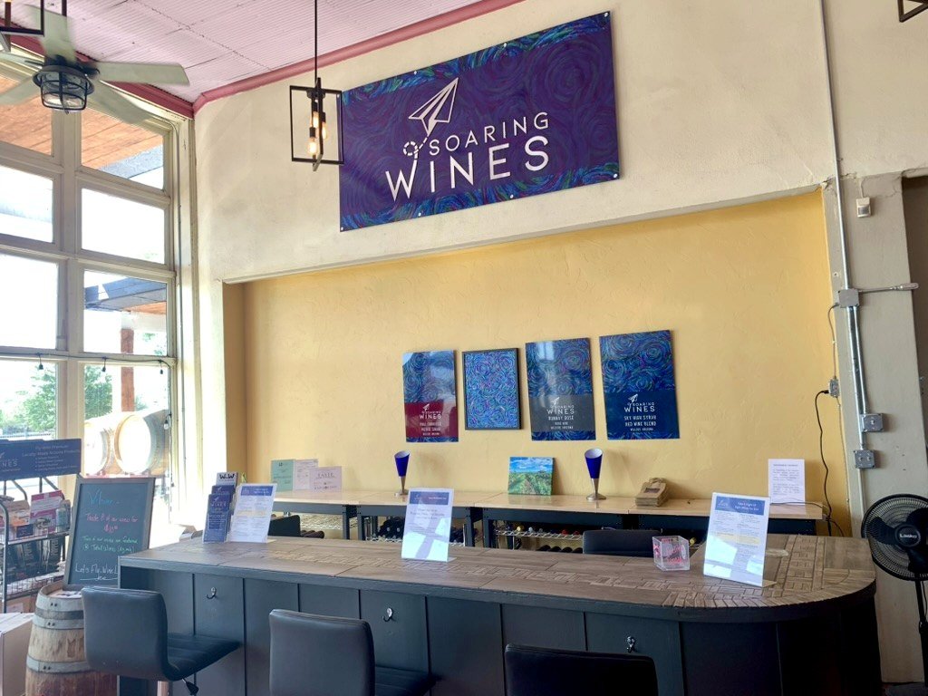 The Soaring Wines tasting bar in the historic Willcox Commercial building, with wine label prints on the wall